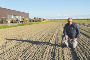 A main kneeling in a freshly plowed field 